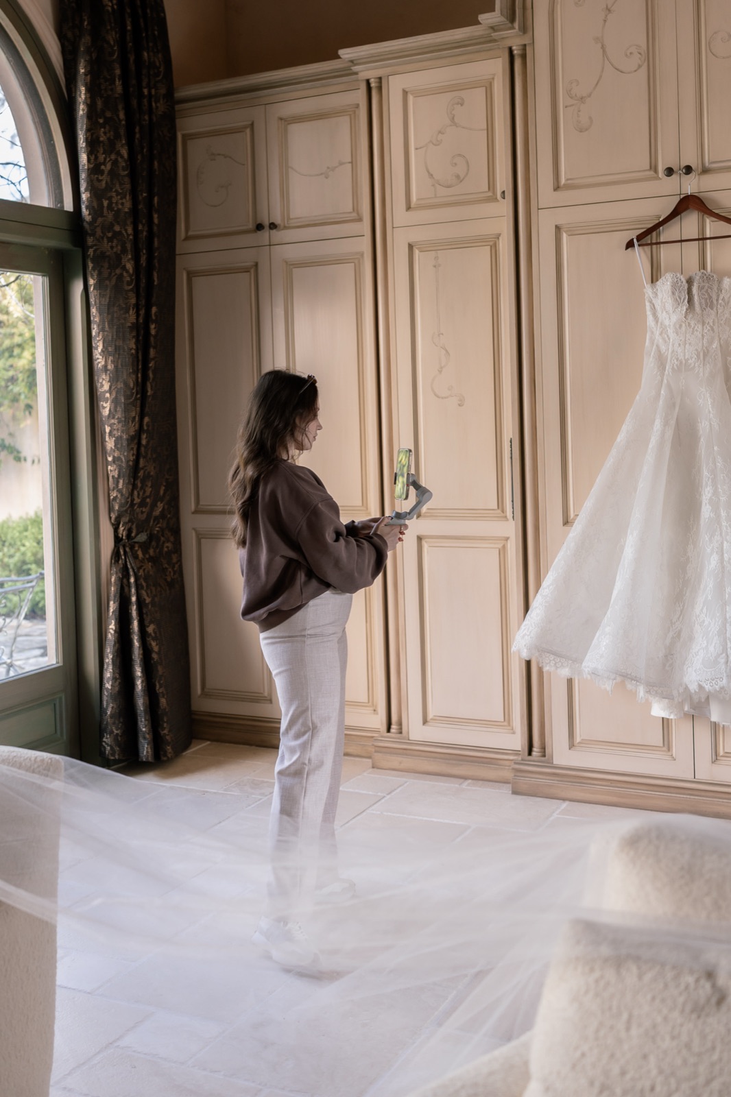 Jaeli filming candidly beside a wedding dress on location